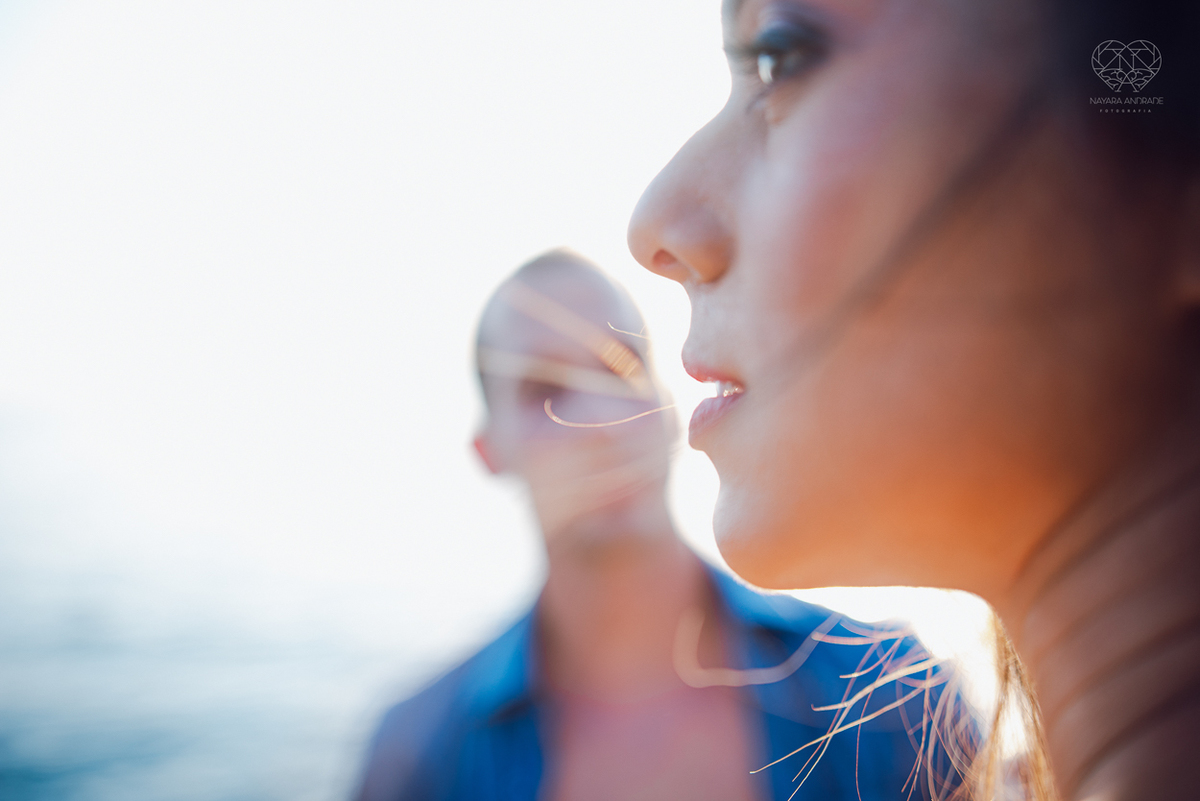 fotografia pre wedding de casal na praia noiva de vestido branco casal fazendo fotos em poses inspiração pela fotografa nayara andrade lindo por do sol colorido e fotos artisticas pela fotografa premiada mundialmente casamentos de dia inspiração
