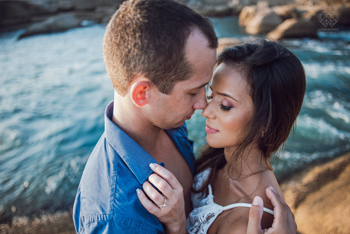 fotografia pre wedding de casal na praia noiva de vestido branco casal fazendo fotos em poses inspiração pela fotografa nayara andrade lindo por do sol colorido e fotos artisticas pela fotografa premiada mundialmente casamentos de dia inspiração