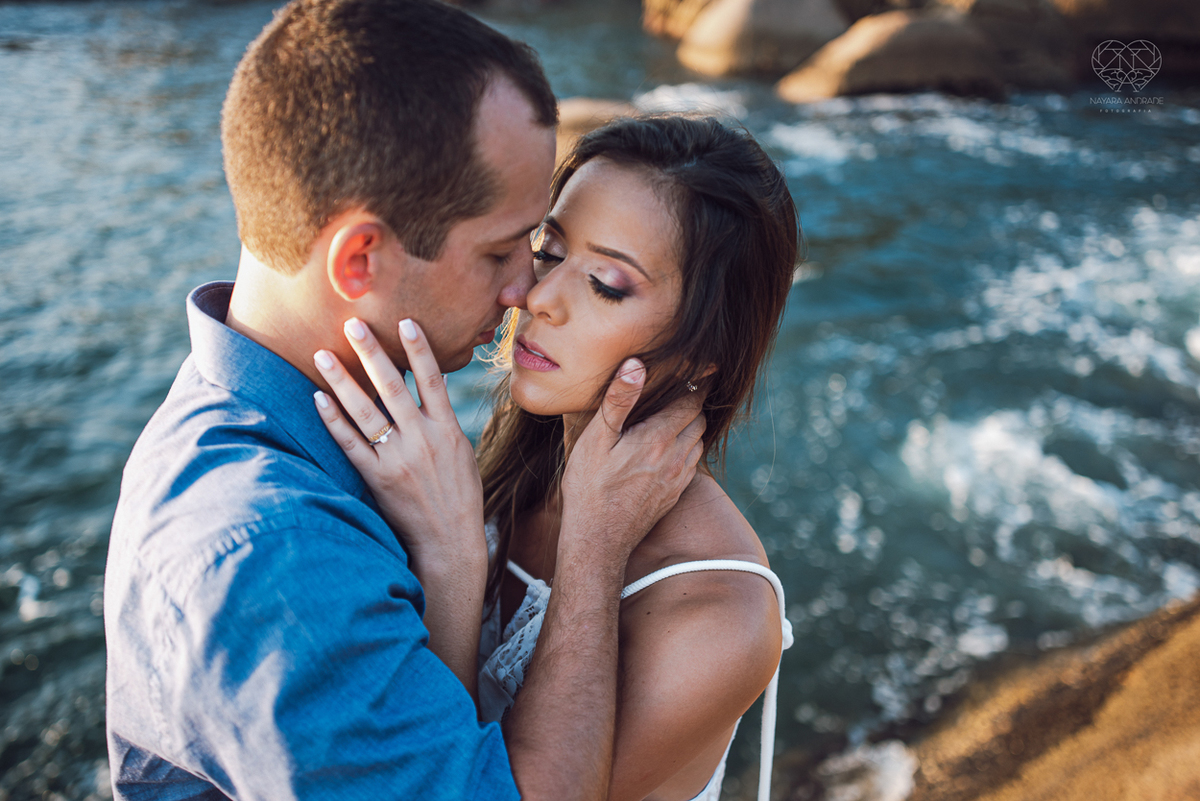 fotografia pre wedding de casal na praia noiva de vestido branco casal fazendo fotos em poses inspiração pela fotografa nayara andrade lindo por do sol colorido e fotos artisticas pela fotografa premiada mundialmente casamentos de dia inspiração