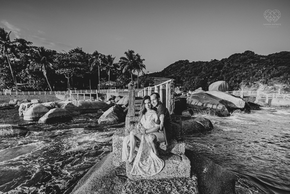fotografia pre wedding de casal na praia noiva de vestido branco casal fazendo fotos em poses inspiração pela fotografa nayara andrade lindo por do sol colorido e fotos artisticas pela fotografa premiada mundialmente casamentos de dia inspiração