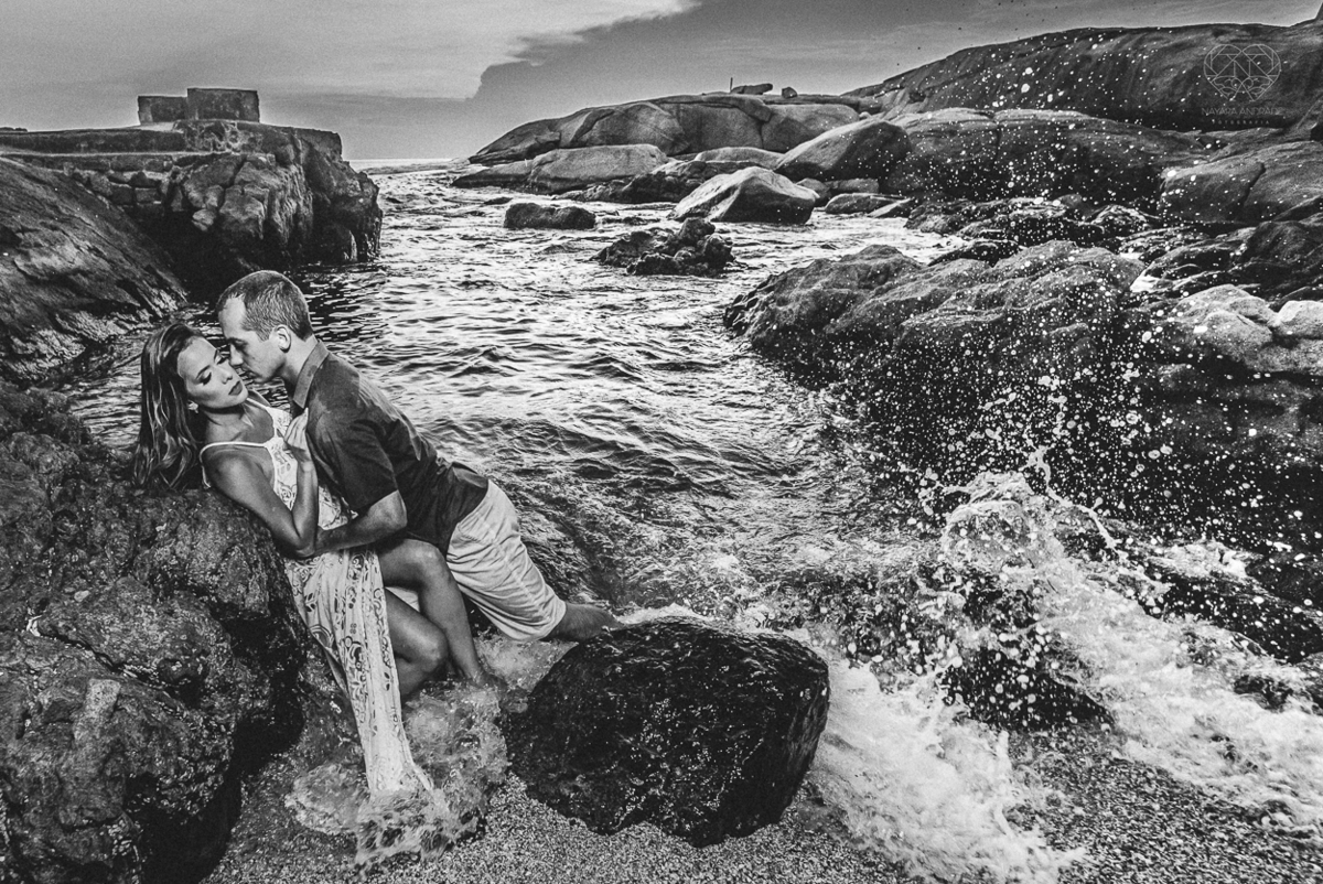 fotografia pre wedding de casal na praia noiva de vestido branco casal fazendo fotos em poses inspiração pela fotografa nayara andrade lindo por do sol colorido e fotos artisticas pela fotografa premiada mundialmente casamentos de dia inspiração