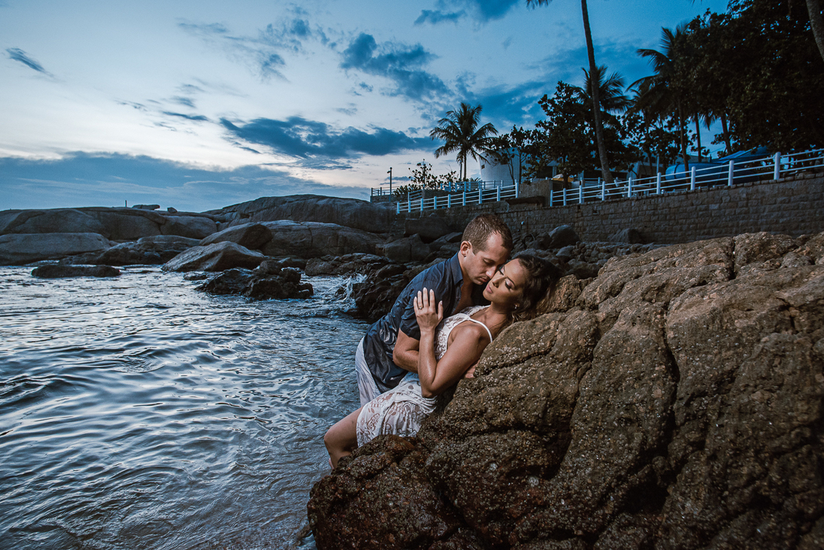 fotografia pre wedding de casal na praia noiva de vestido branco casal fazendo fotos em poses inspiração pela fotografa nayara andrade lindo por do sol colorido e fotos artisticas pela fotografa premiada mundialmente casamentos de dia inspiração