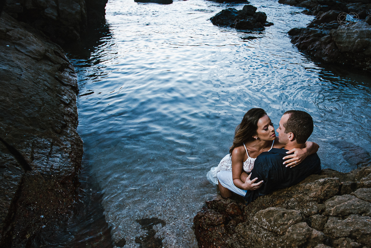 fotografia pre wedding de casal na praia noiva de vestido branco casal fazendo fotos em poses inspiração pela fotografa nayara andrade lindo por do sol colorido e fotos artisticas pela fotografa premiada mundialmente casamentos de dia inspiração