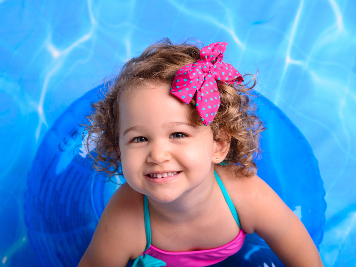 Sessão Verão, bóia, piscina, água, sol, bronzeado, biquíni, laço rosa, criança loira.