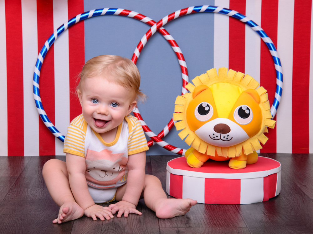 sessão circo, leão, bebê loiro, olhos azuis, alegria, bambolê.