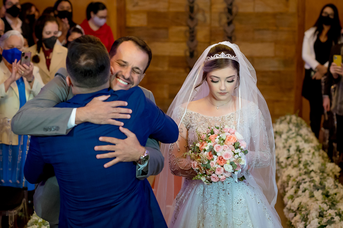 Pai da noiva a entregando para o noivo e o abraçando