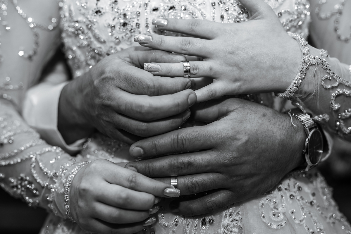 Noivos colocando as alianças com as mãos trocadas