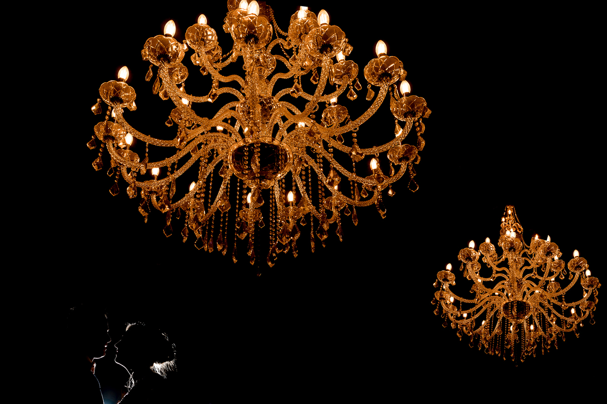 Uma bela dupla exposição utilizando os enormes lustres do espaço com um belo recorte dos noivos no canto inferior esquerdo.