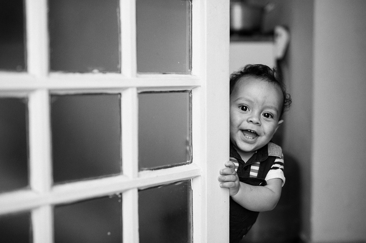 Brincando de esconde esconde com o fotógrafo de família de casamentos. ensaio de crianças.