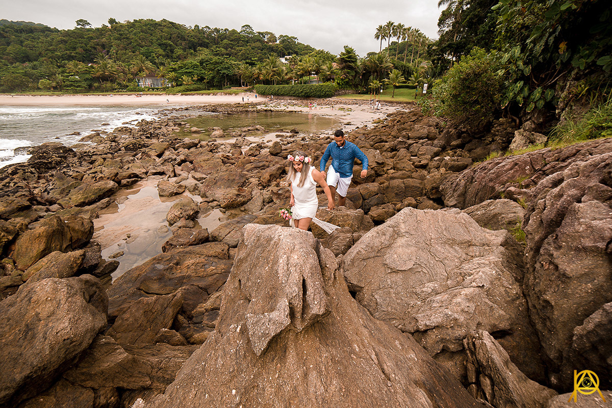 fotografia Paulo Araujo, montanhas, na praia de guarujá, casal caminhando na areia da praia, céu com nuvens, nas pedras da praia de são pedro