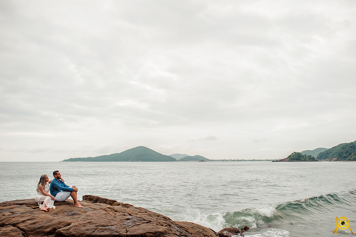 fotografia Paulo Araujo, na praia de guarujá, céu com núvens, nas pedras da praia de são pedro, fotógrafo de São paulo e ABC, sentados na pedra vendo a paisagem