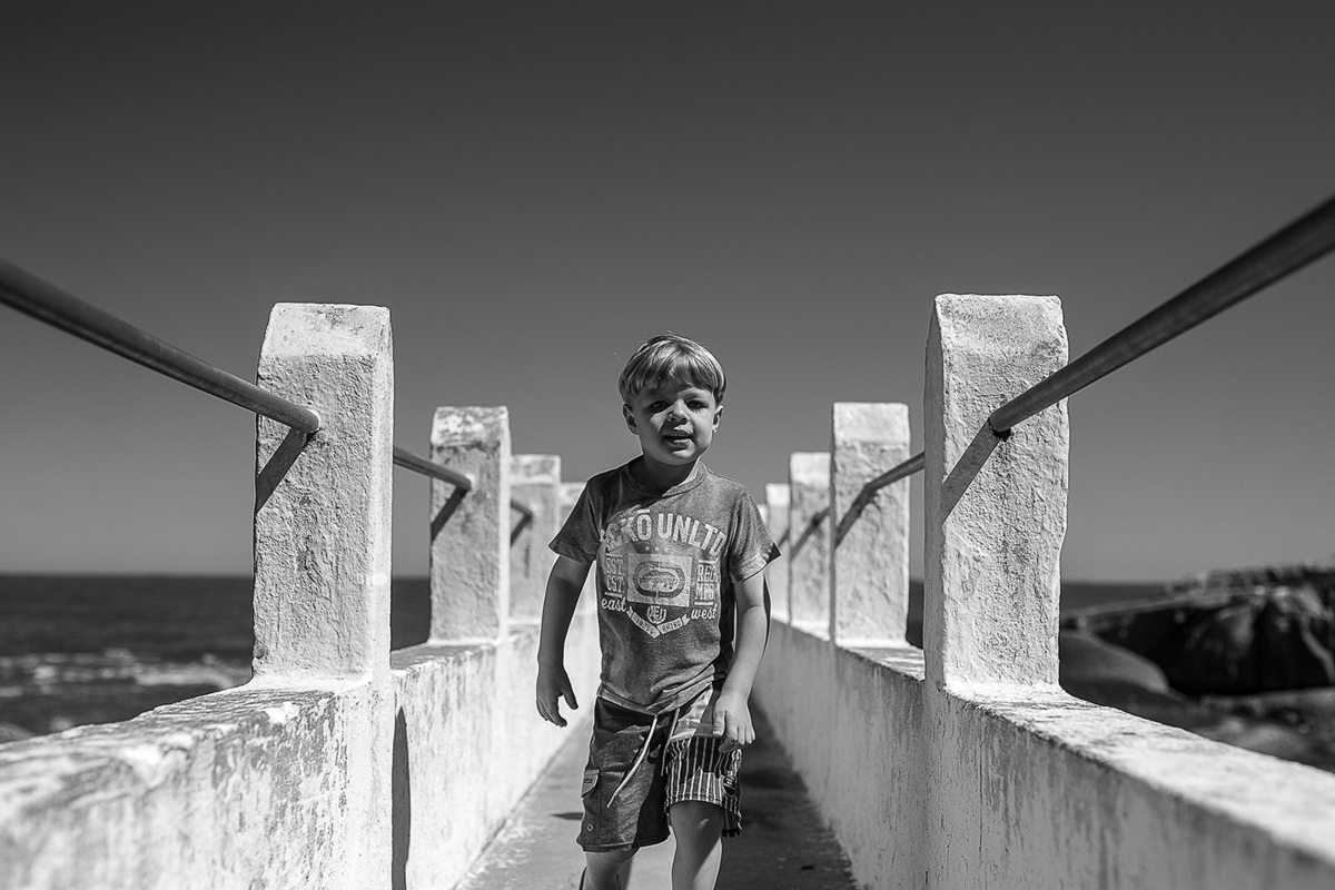 foto Ilha do Porchat - santos - praia de são vicente - fotografia Paulo Araujo, ensaio de família, lifestyle, criança andando na ponte da praia