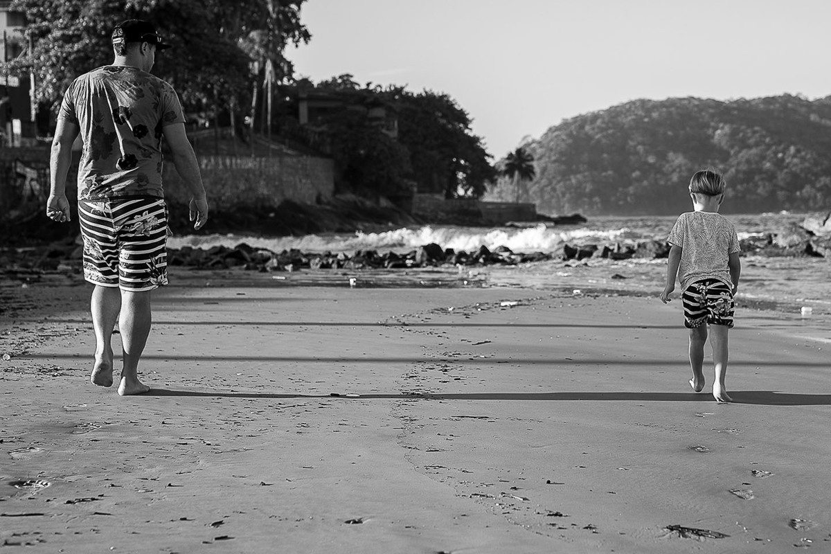 foto Ilha do Porchat - santos - praia de são vicente - fotografia Paulo Araujo, ensaio de família, lifestyle, pai e filho caminhando lado a lado na areia da praia