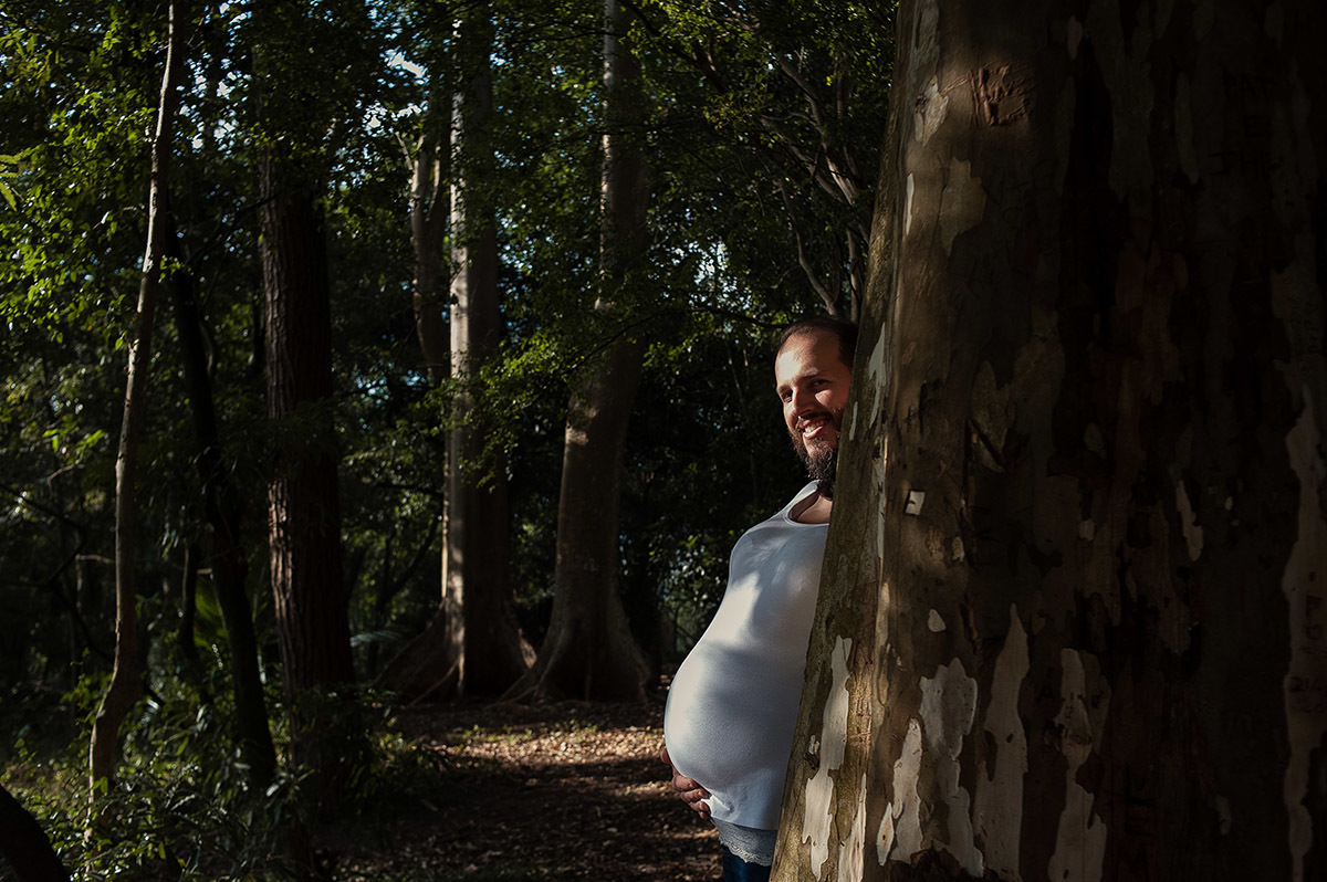 Foto criativa de casal em ensaio fotográfico de gestante, barriga da esposa e rosto do marido.
