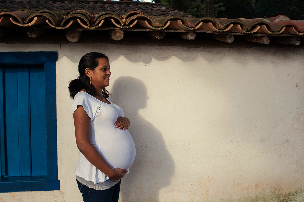 Foto criativa de casal em ensaio fotográfico de gestante, sombra do casal projetada na parede.