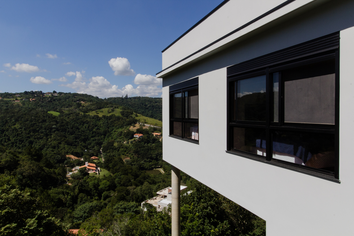 #ParaCegoVer: Fotografia colorida da fachada Lateral com vista para a mata da residência CT Quebec