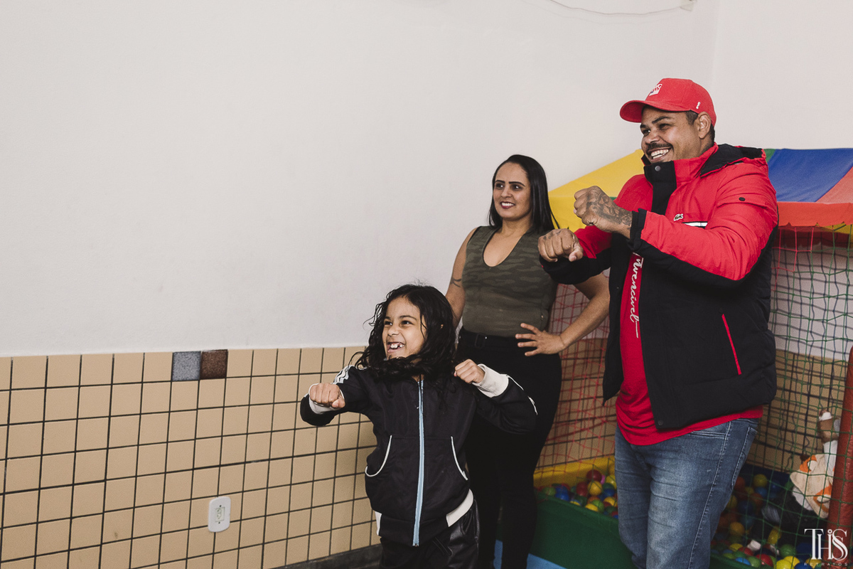 Foto de criança brincando com adultos no vídeo game em festa infantil na cidade de São Bernardo do Campo - SP