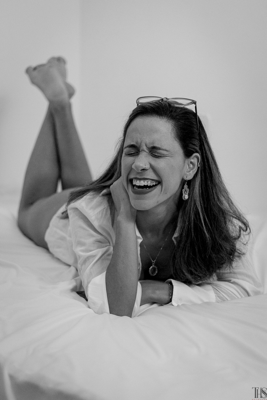 Fotografia preto e branco de mulher rindo na cama