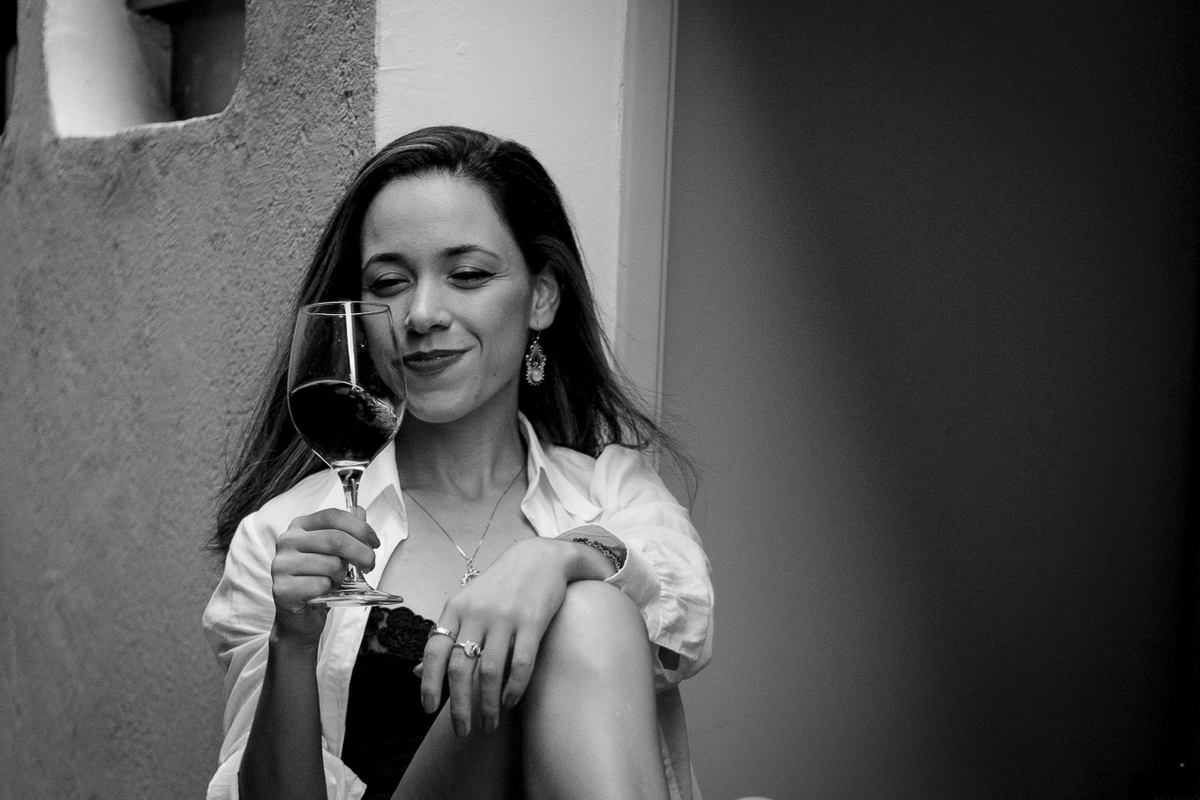 Fotografia preto e branco de mulher em casa tomando vinho