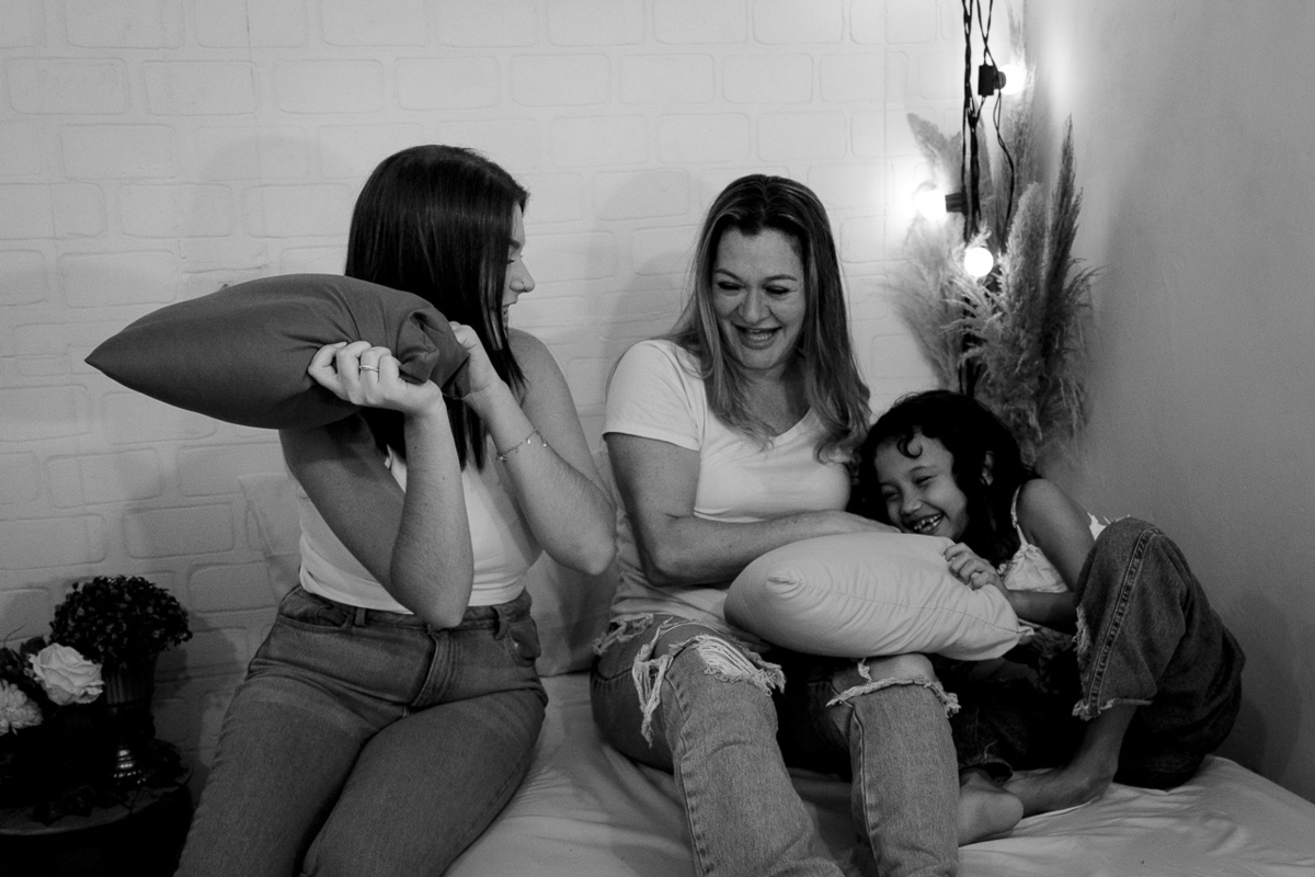 Foto preto e branco de mãe e filhas brincando