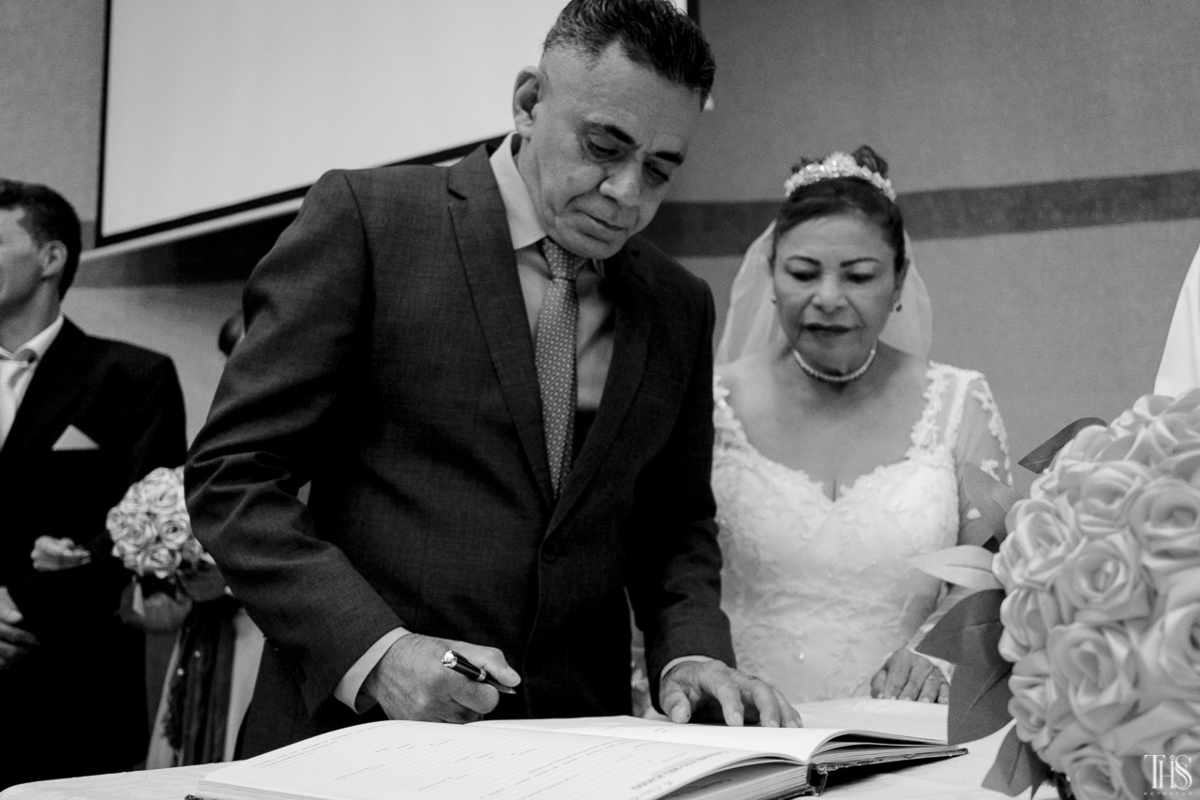 Noivos assinando certidão de casamento em preto e branco - Fotografa em SBC