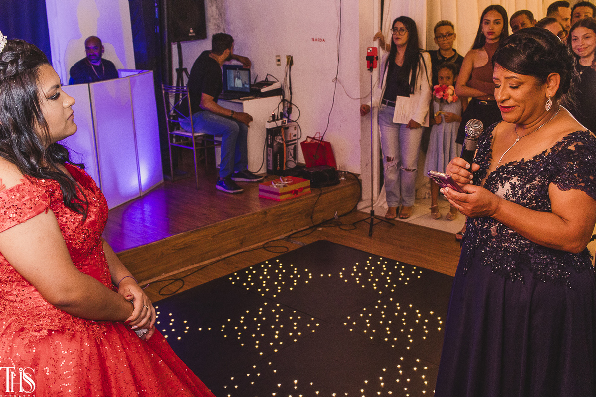 Foto da mãe lendo uma mensagem para debutante