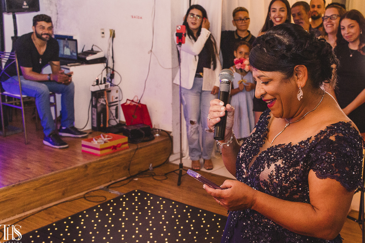 Foto da mãe de debutante lendo sua mensagem para filha