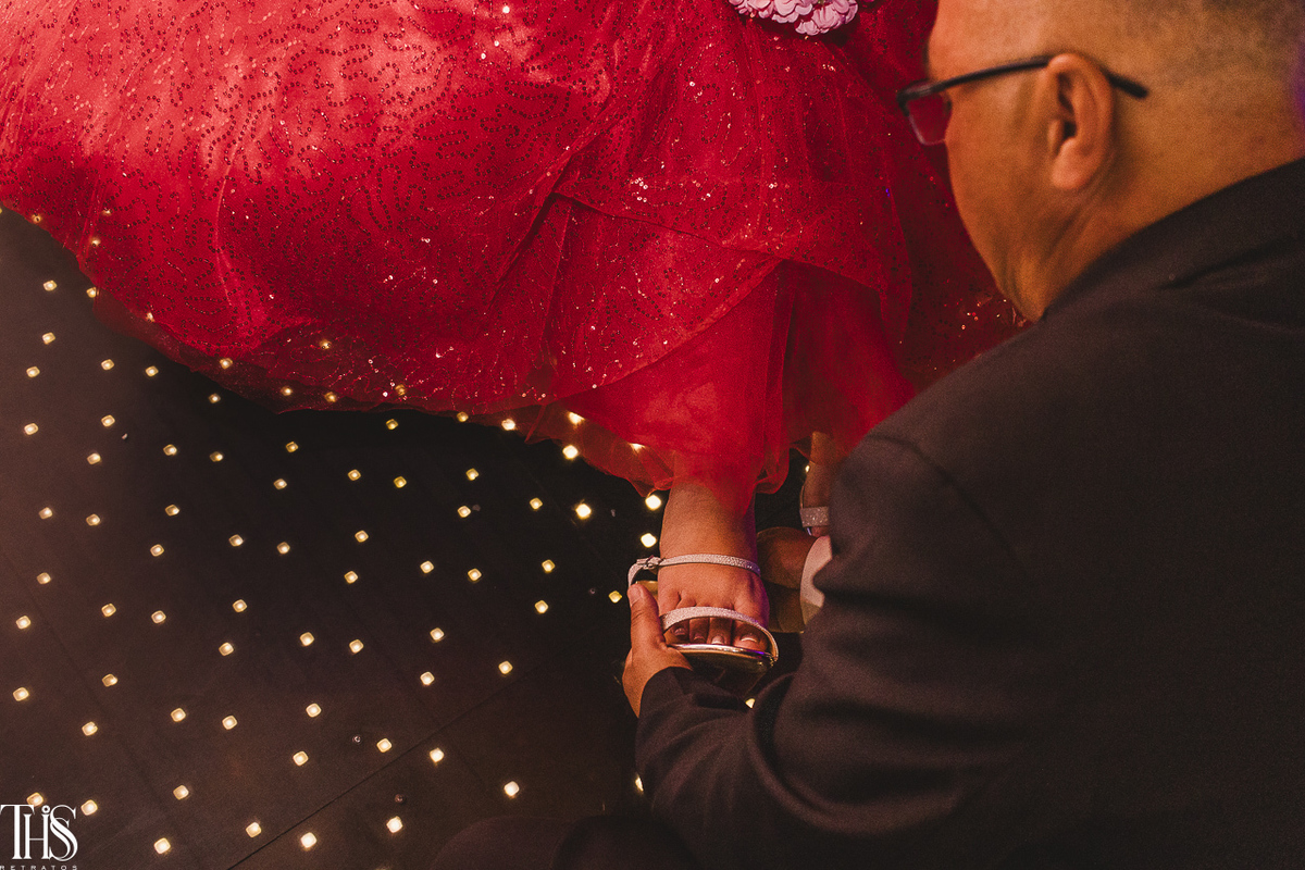 Foto em festa debutante do momento em que o pai coloca o salto na filha