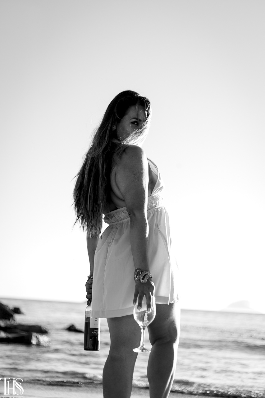 Foto de mulher com seu vinho na praia