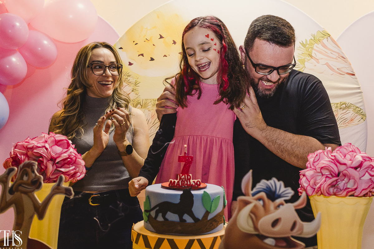 Aniversariante de 7 anos com os pais na mesa do bolo em festa infantil - Fotografa em SBC