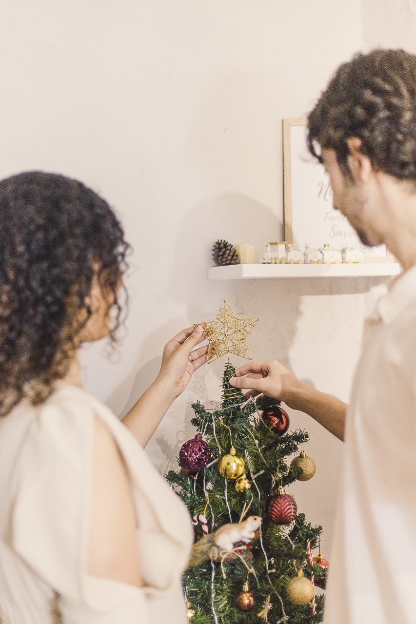 casal colocando estela em arvore em ensaio de natal -Fotografa em SBC