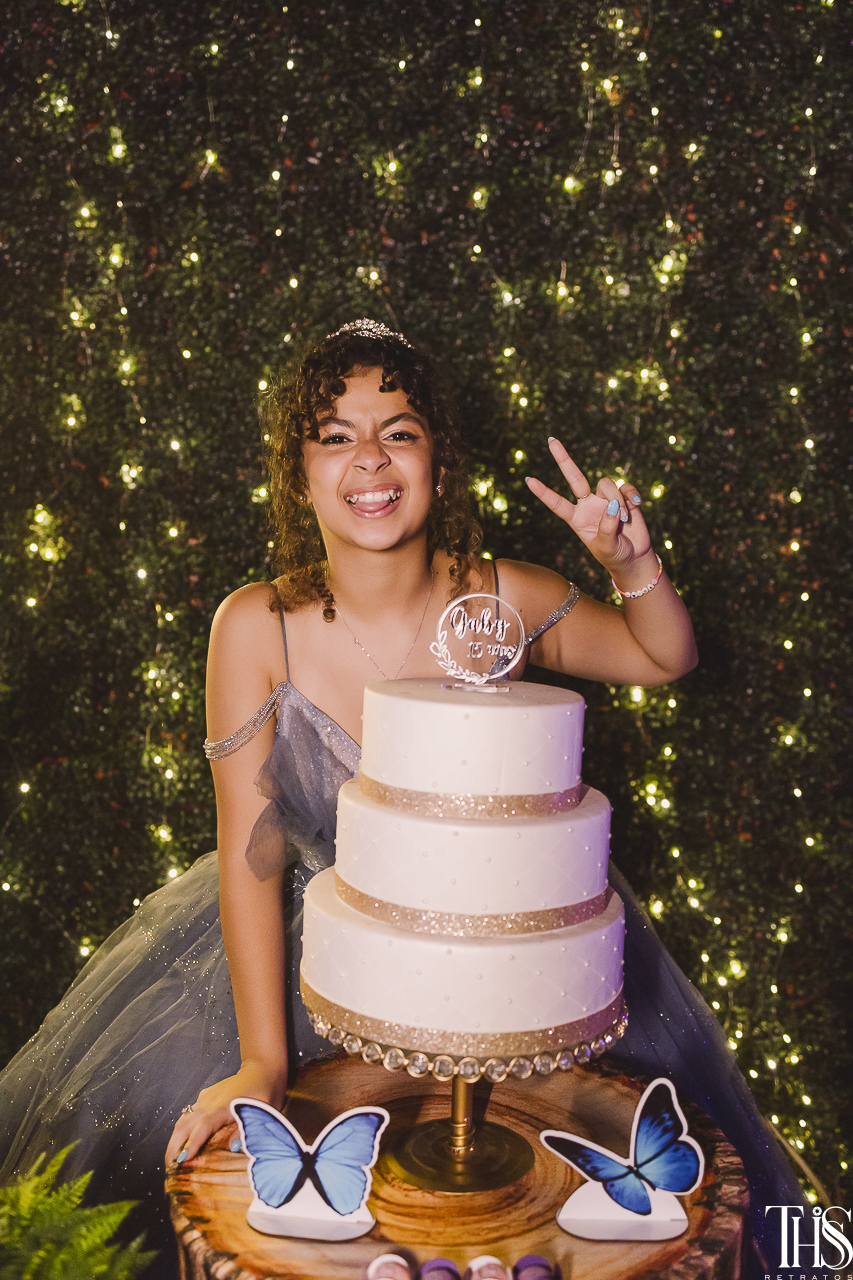 debutante na mesa do bolo fazendo pose - fotografa em sbc sp
