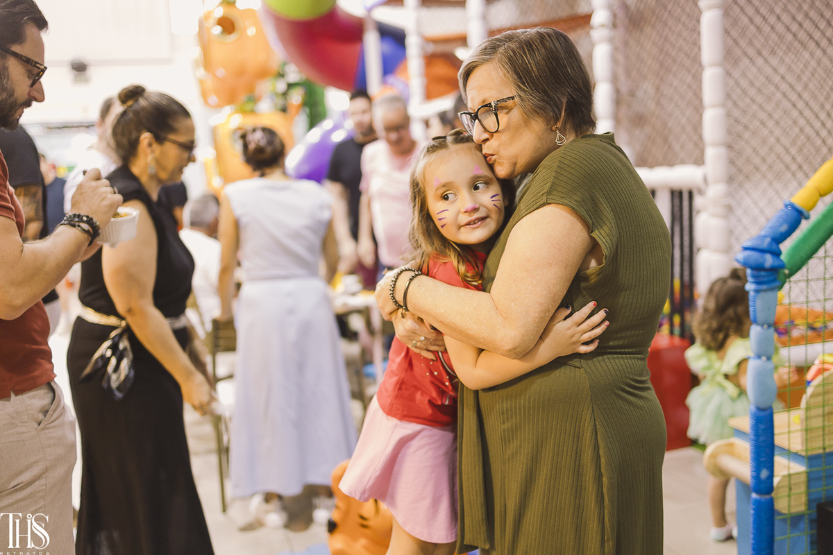 menina de 4 anos abraçando avó em festa infantil - fotografa em sbc sp
