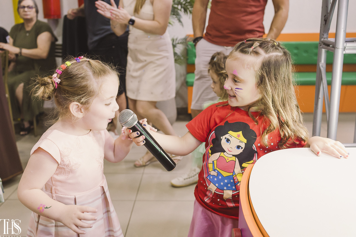 menina segurando microfone para outra criança momento fofo festa infantil - fotografa em sbc sp