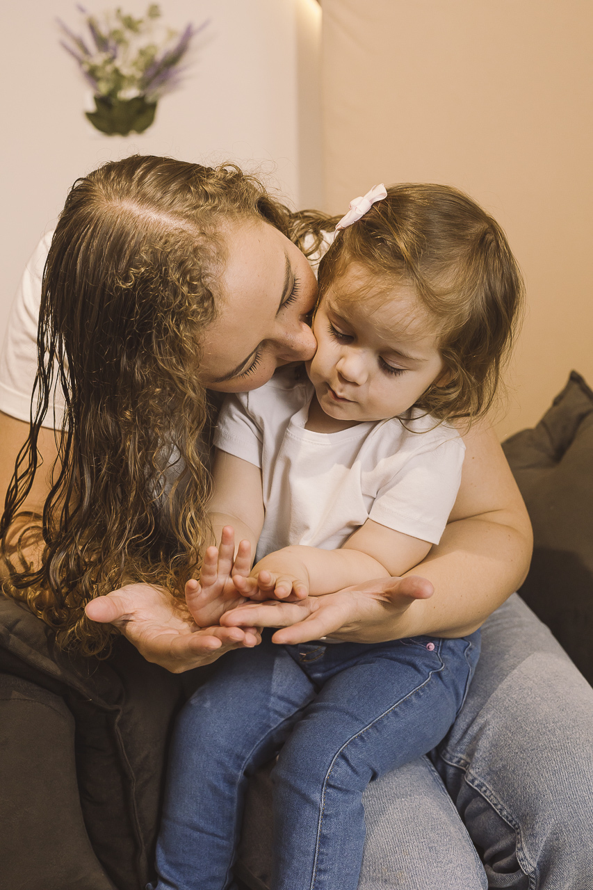 mãe beijando bochecha filha pequena ensaio dia das mães
