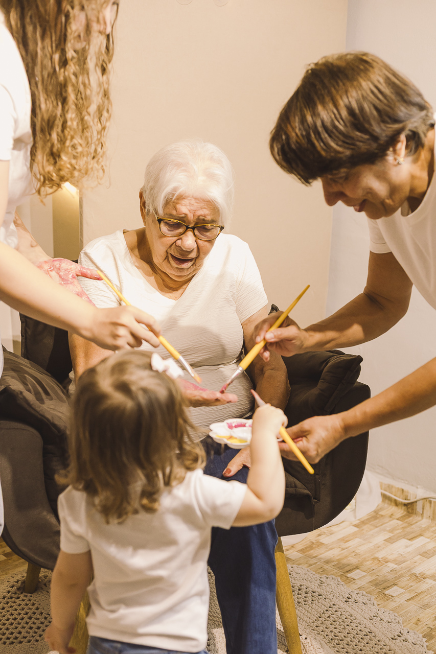 familia pintando mão de bisavó em ensaio dia das mães