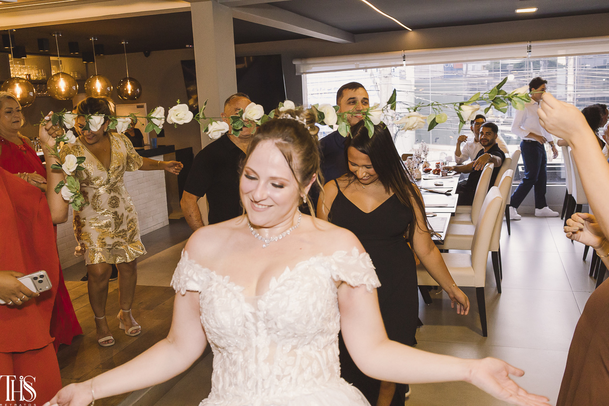 noiva dançando passando por baixo de varal de flores - fotografa em sp sbc