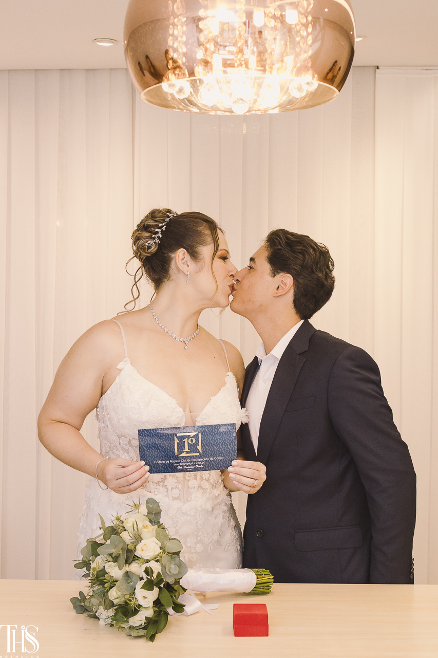 noivos se beijando segurando papel - fotografa em sp sbc