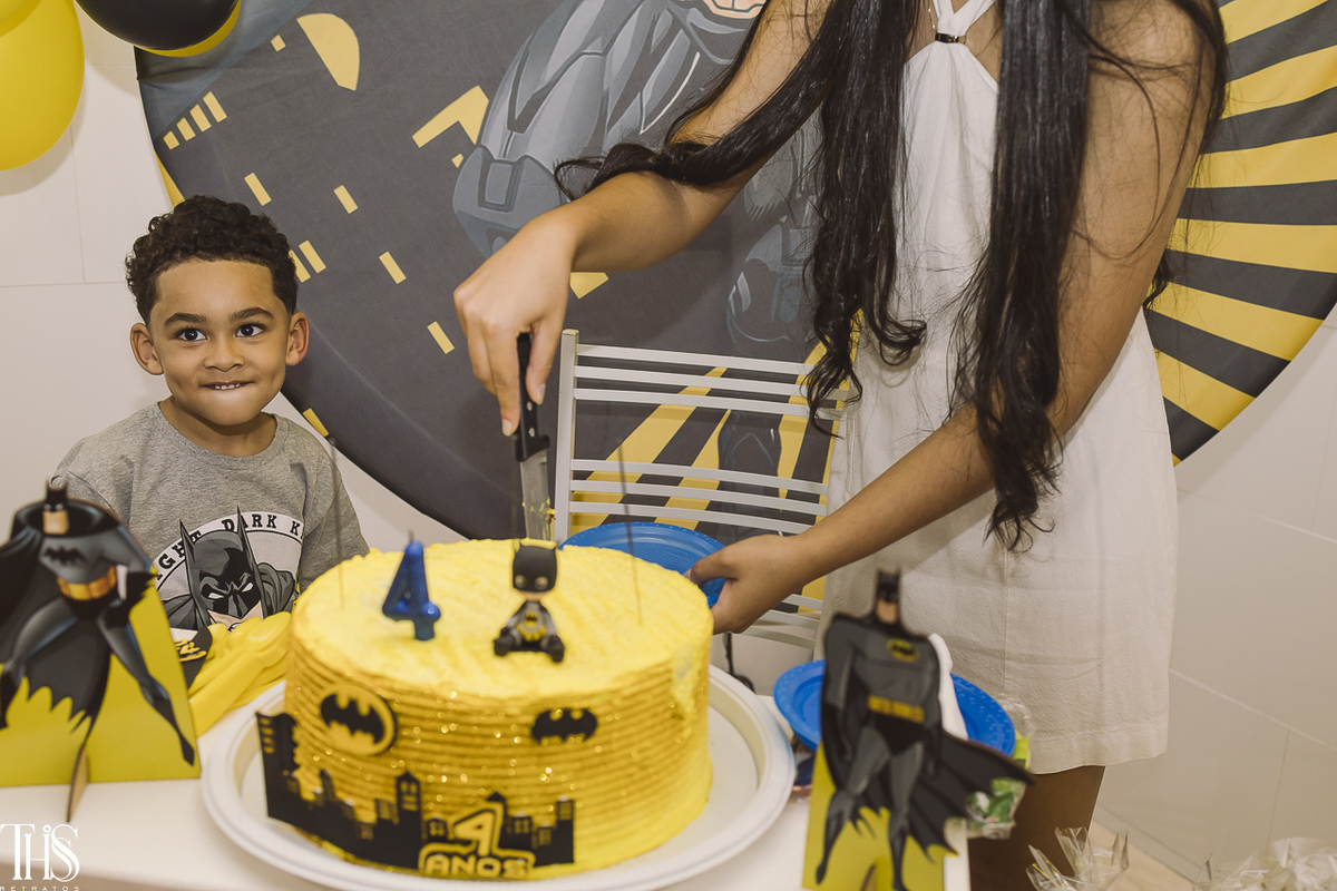 mãe cortando bolo com criança de fundo em festa infantil - fotografa em sp sbc abc