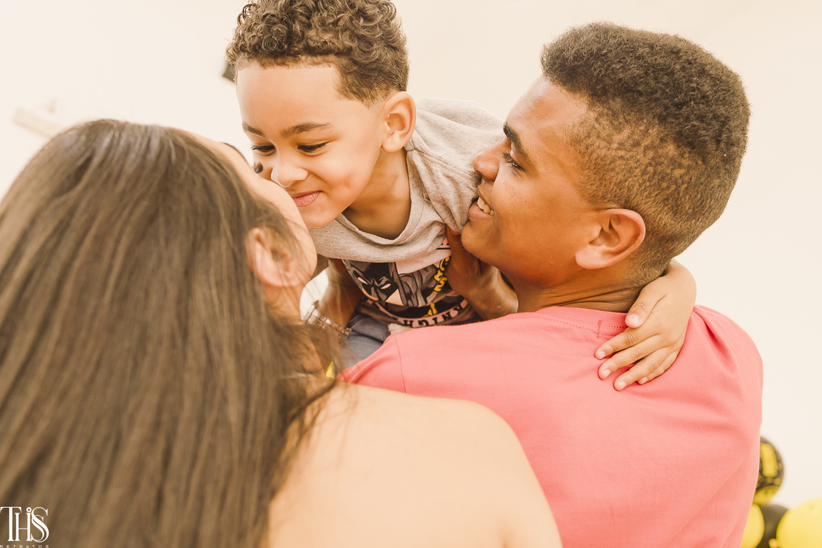 pai segurando menino com mãe do lado em festa infantil - fotografa em sp 