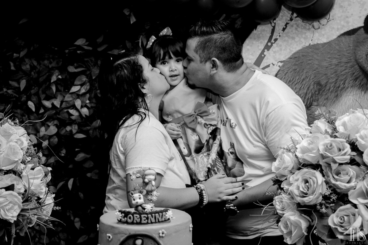 Foto dos pais beijando a filha na mesa do bolo em festa infantil na cidade de Santo André - SP