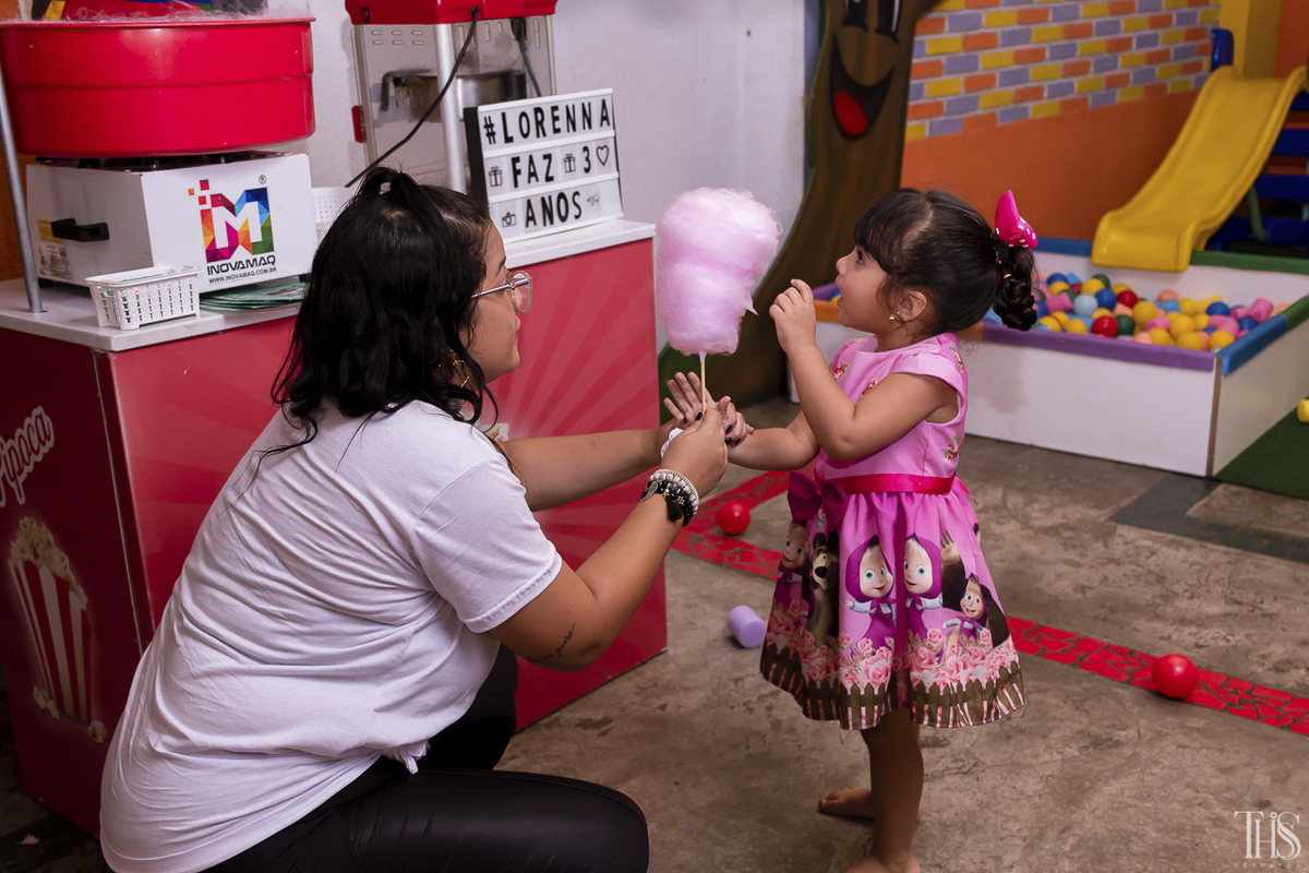 Foto de aniversariante comendo algodão doce em festa infantil