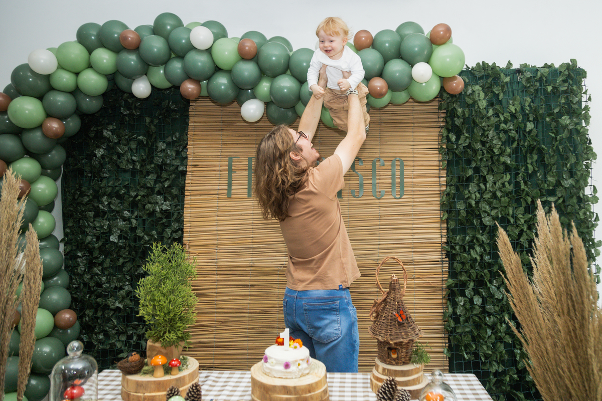 Foto do aniversáriante no ar, sendo jogado pra cima pelo pai.