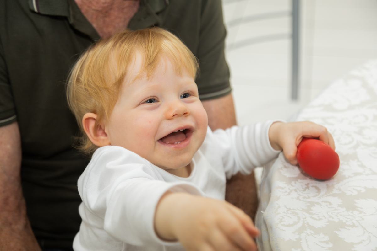 Foto do aniversariante olhando para o lado com um grande sorriso.
