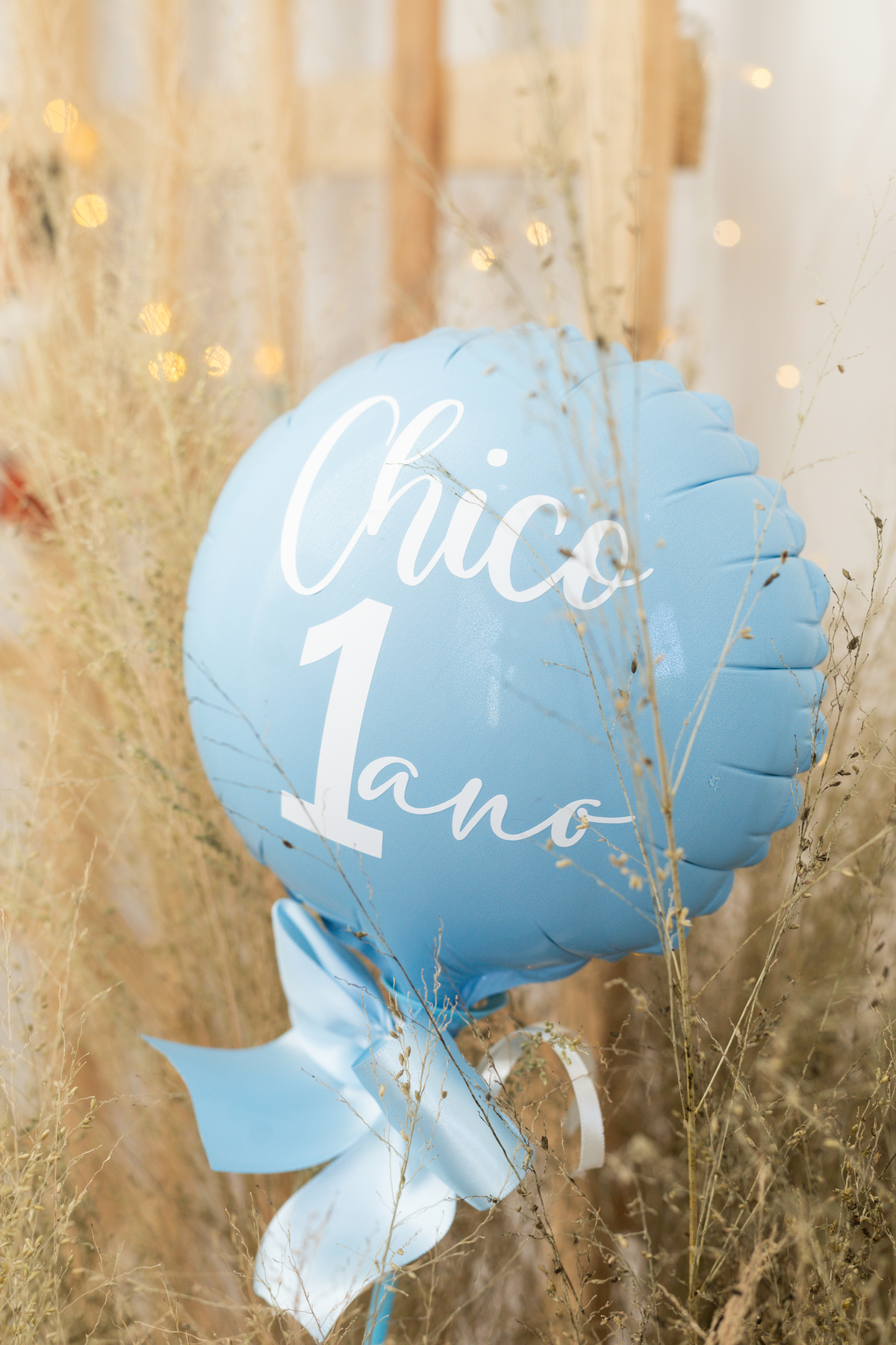 Foto de detalhe da decoração com um balão azul claro, com a escrita: Chico 1 Ano!