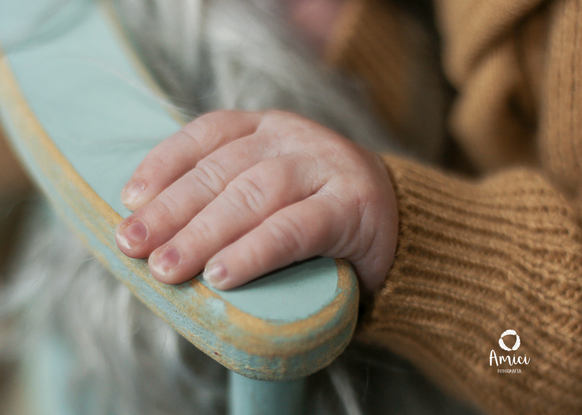 Newborn, fotografia macro destacando os detalhes da pequena mão do recém nascido.