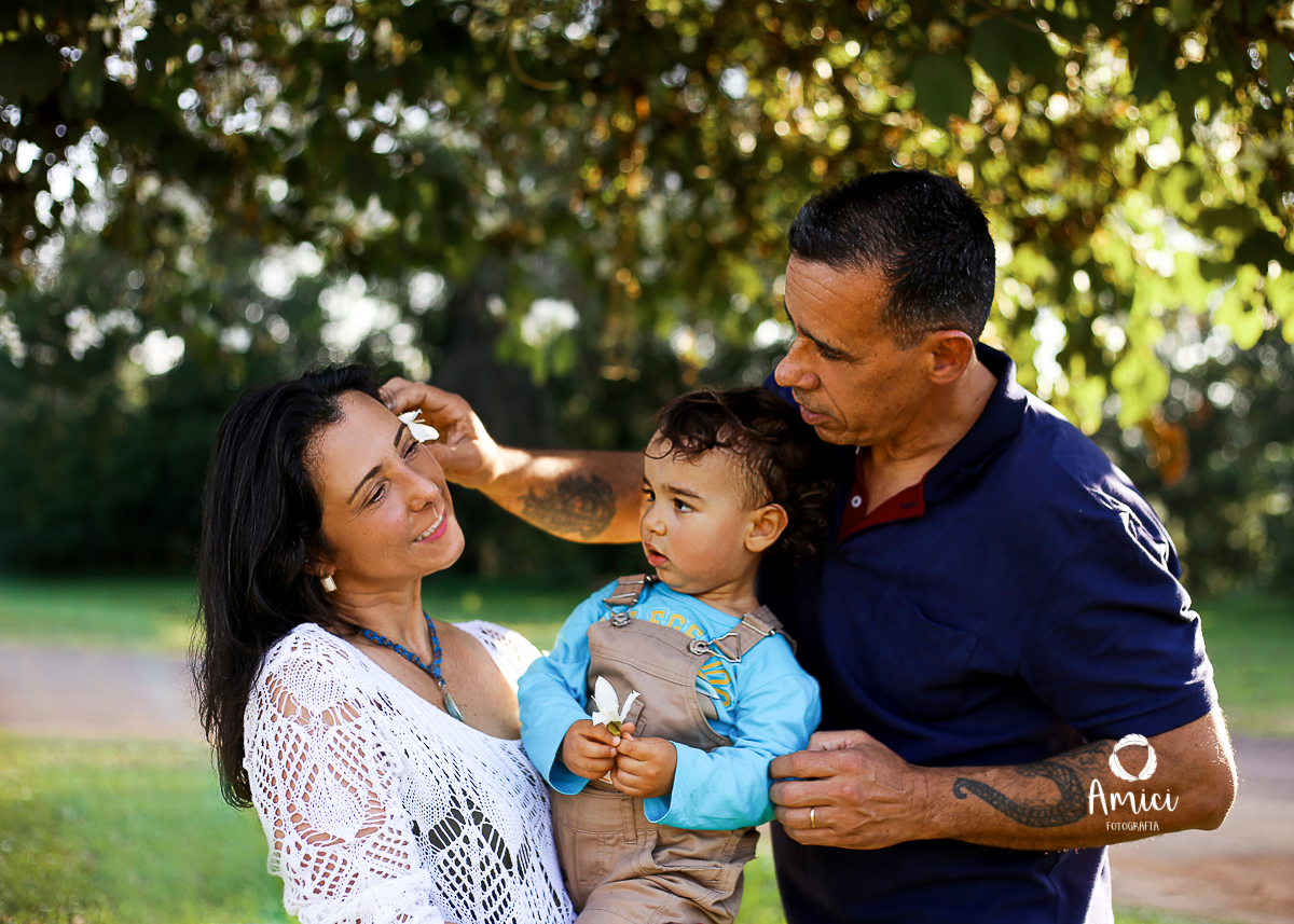 Fotografia da família, com o menino no colo da mãe.