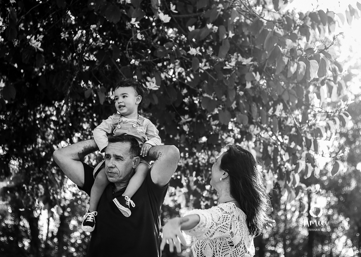 Fotografia preto e branco da família, menino nos ombros do pai.