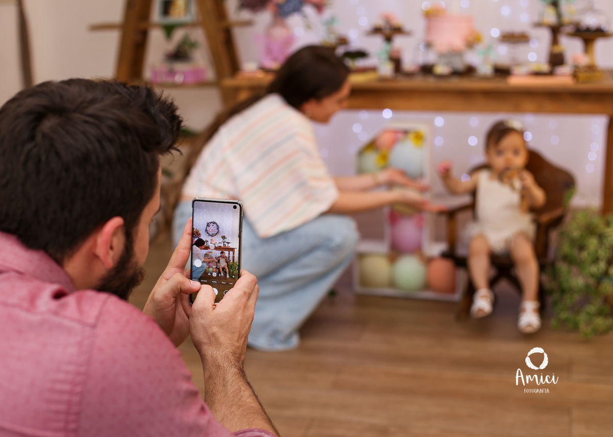 Fotografia life style, pai fotografando com o celular a mãe e bebê.
