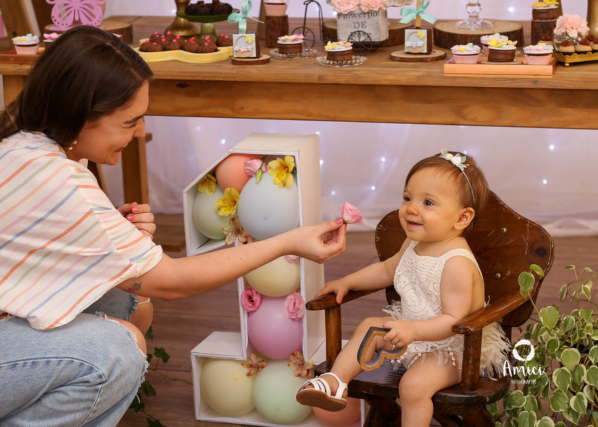 Fotografia infantil, ma~e e filha brincando com flores.